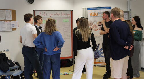 Kleingruppe steht um Flipchart zum Thema Kinder und Jugendgerechte Beteiligung.